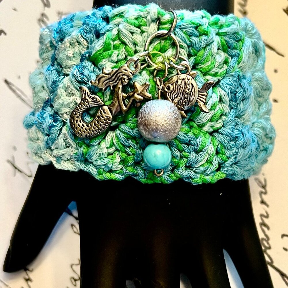 HAND CROCHETED CUFF EMBELLISHED WITH MERMAID & FISH CHARMS IN COLORS BLUE/GREEN